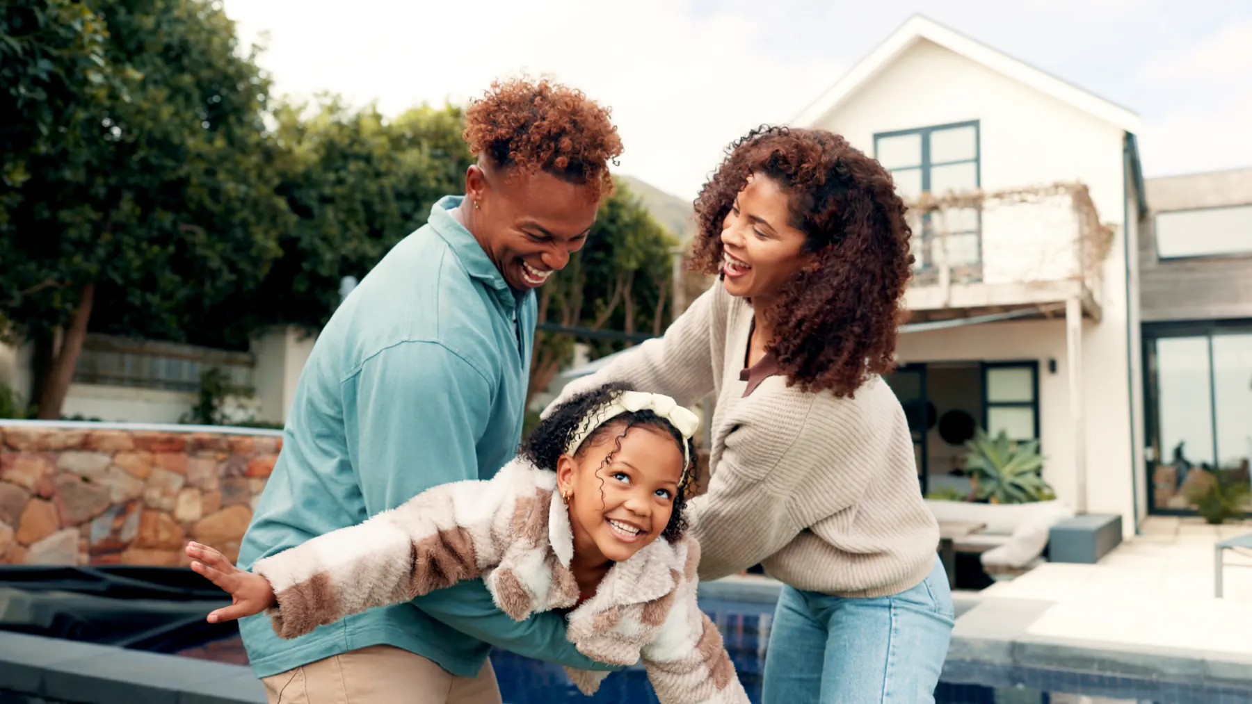 Family smiling together outside their home
