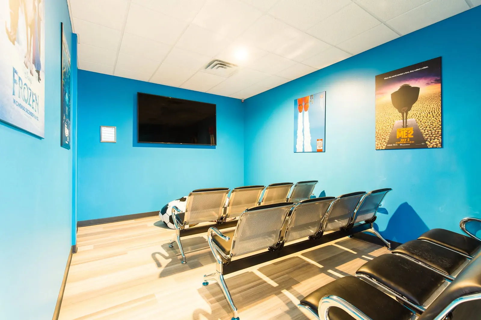 Movie theater room with rows of chairs and a wall-mounted screen